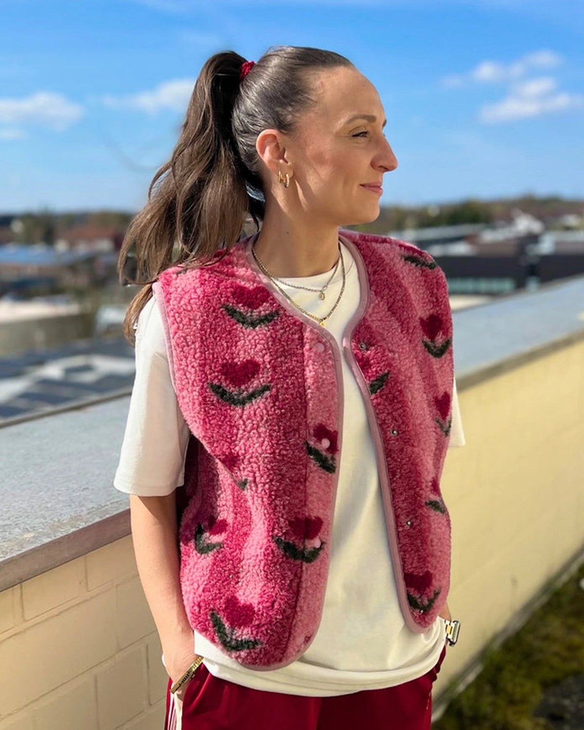 Frau trägt die rosa TYB Wollweste mit Blumenmuster