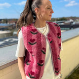 Frau trägt die rosa TYB Wollweste mit Blumenmuster