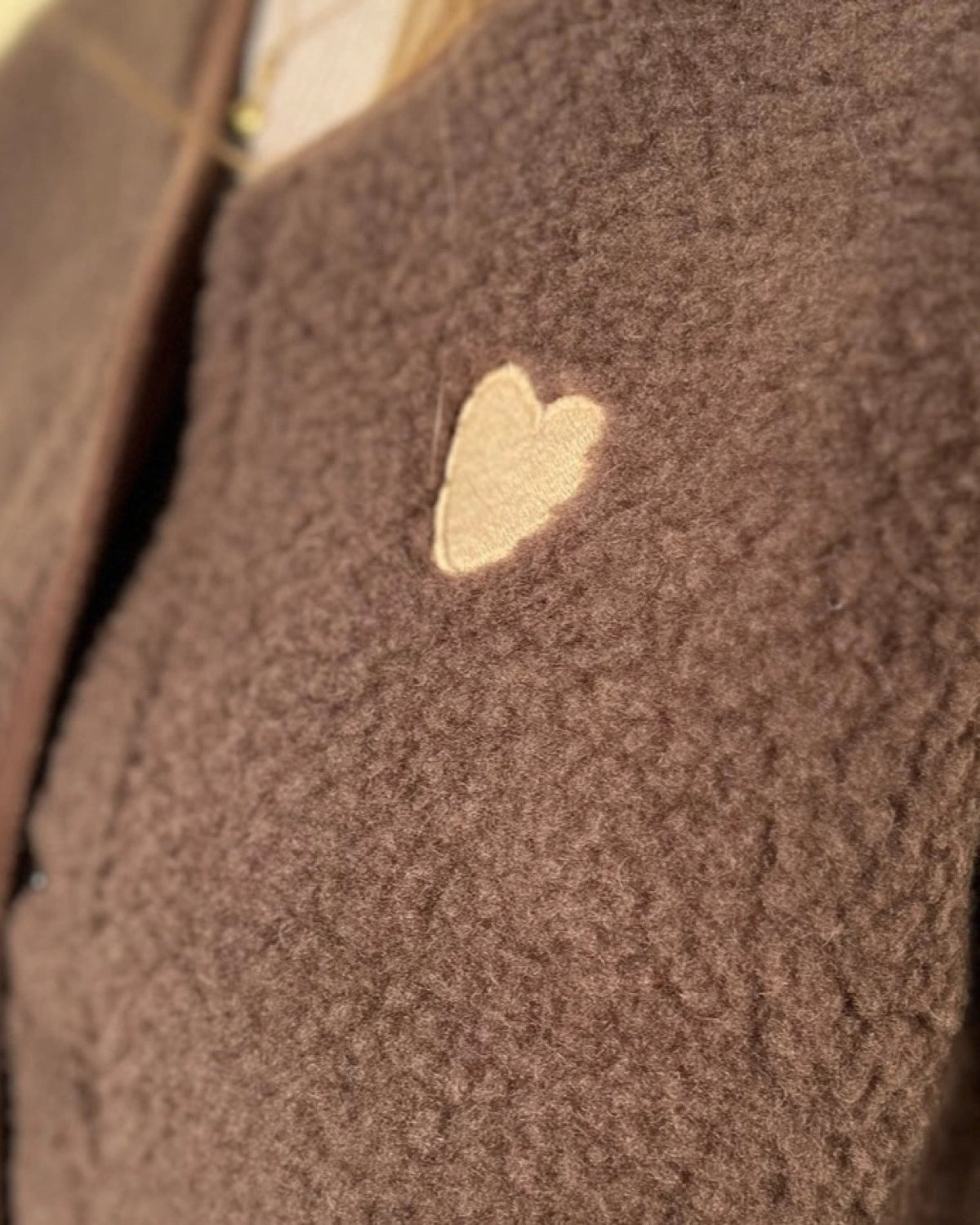 Detailaufnahme des aufgestickten cremefarbenen Herzens